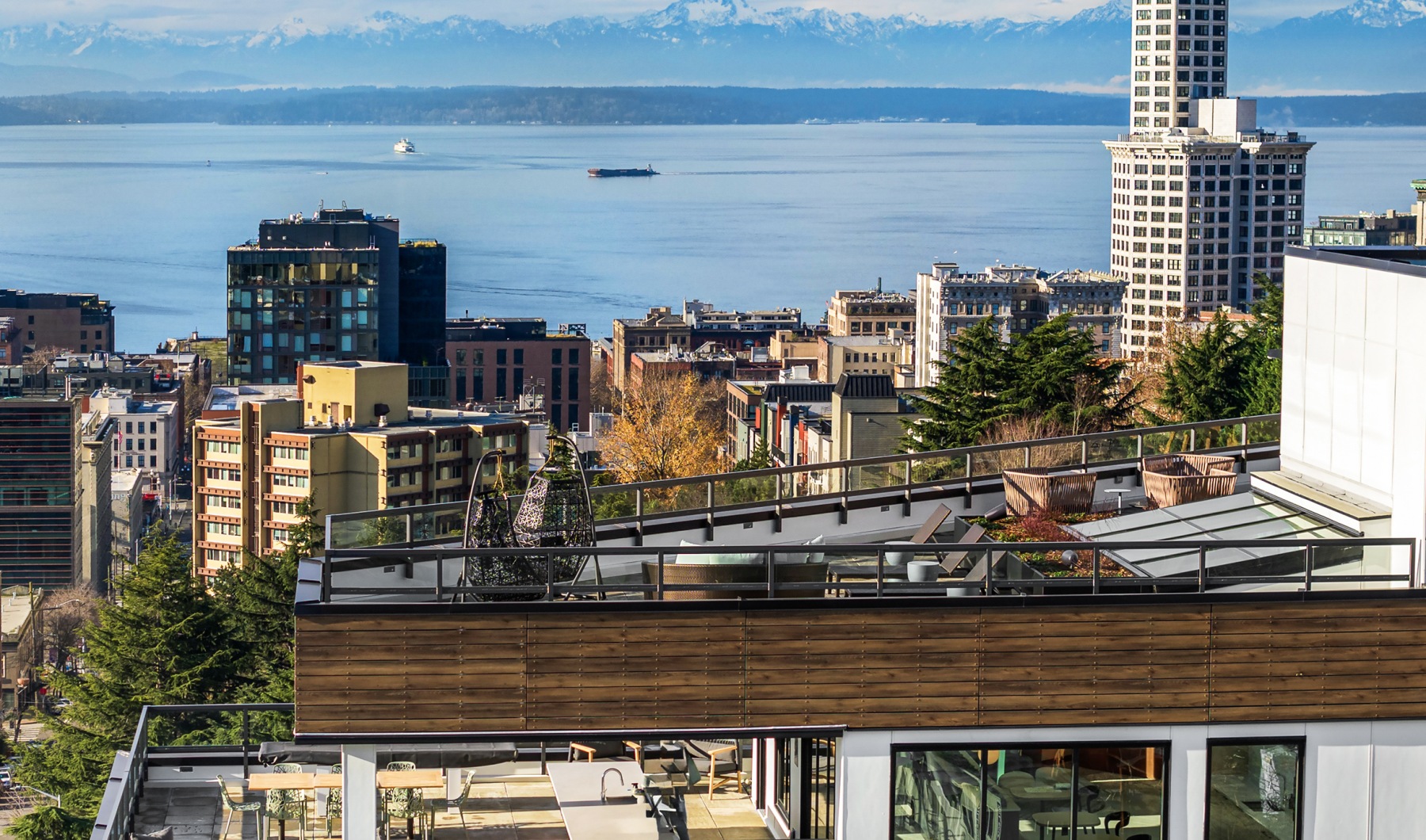 a building with a rooftop terrace and city in the background