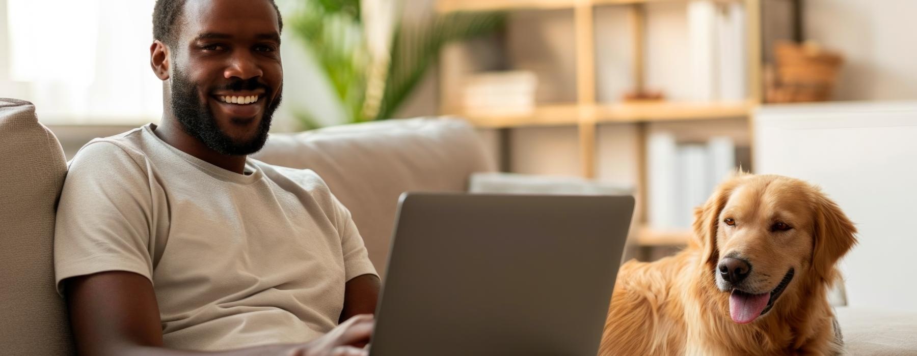 a person and a dog sitting on a couch with a laptop